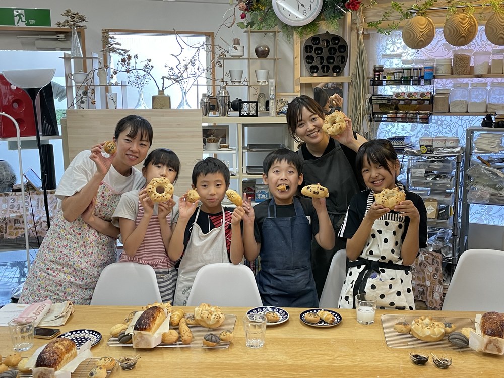 自分で作ったパンを持つ親子教室の参加者